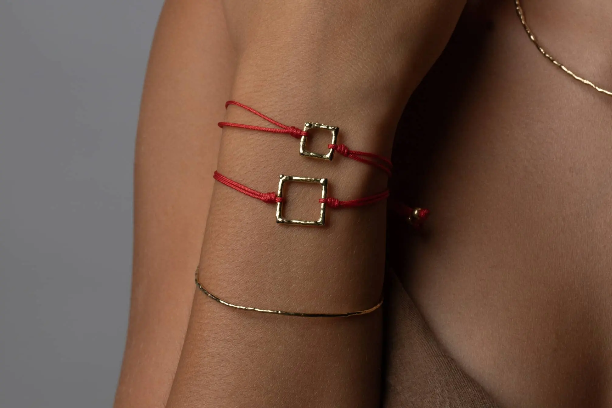 Armbänder aus rotem Faden und Gelbgold aus der Fenicia-Kollektion